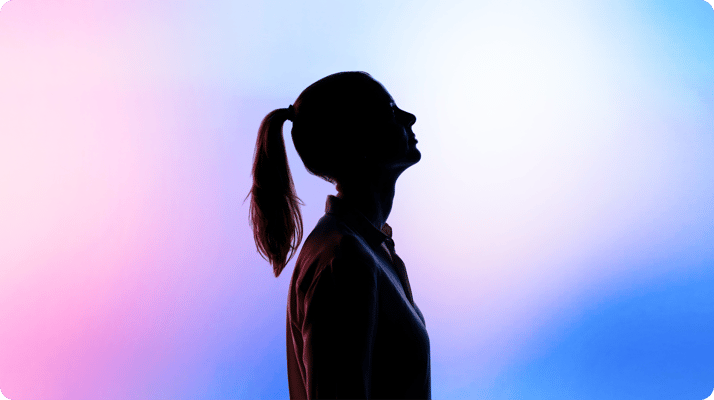 Silhouette of a person with a ponytail, looking upward, set against a gradient background of pink, purple, and blue tones.