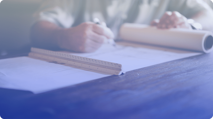 close up of hand with ruler and blueprint 