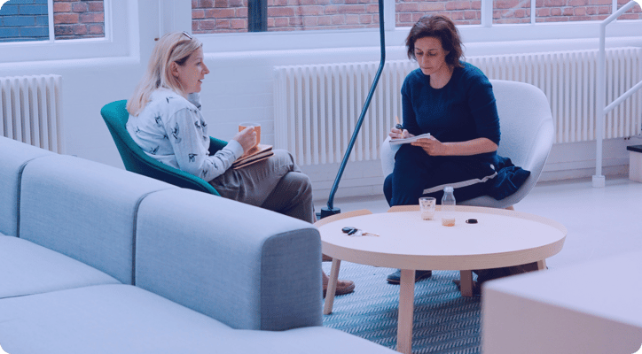 two women sitting and working together